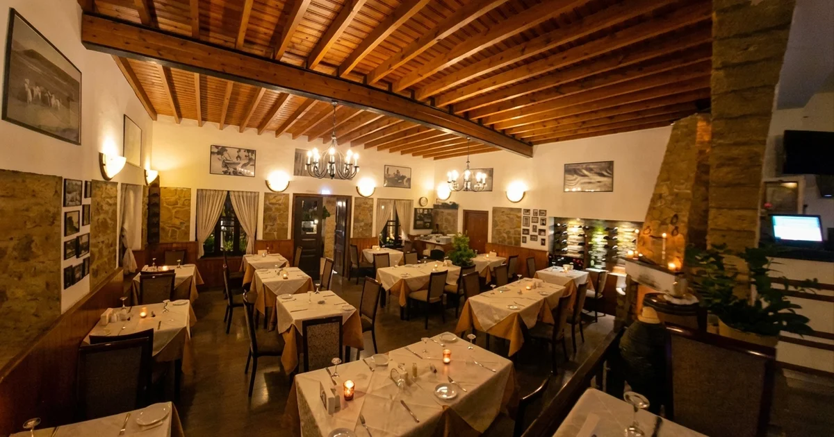 The Windmill main dining room — wooden beams, chandeliers and elegant table settings